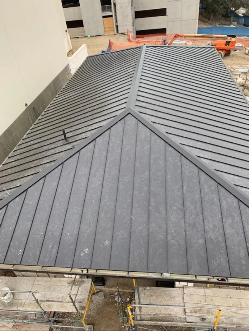 Commercial metal roof construction with crane equipment in Oak Harbor